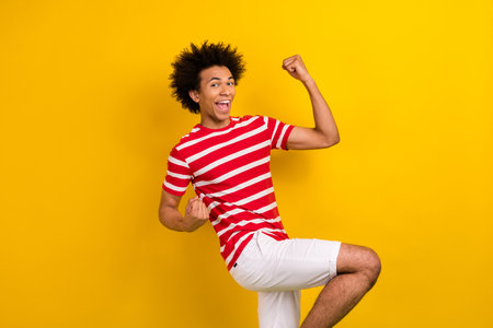 Photo of excited amazed young guy raise fists celebrate victory breakthrough wear shirt shorts...