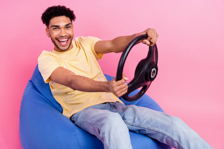 Photo of young overjoyed fast speed drive guy wavy hair steering wheel exploitation car isolated on...