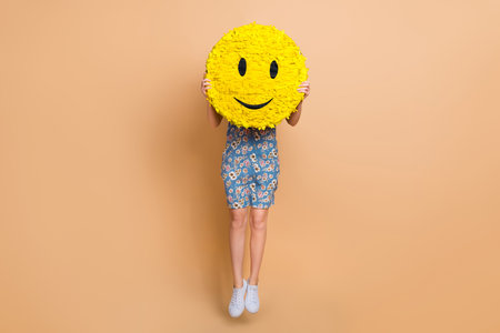 Full length photo of funky excited lady wear flower print dress jumping high smiley close face isolated beige color backgroundの写真素材