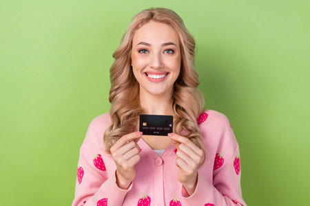 Portrait of gorgeous positive girl toothy smile hands hold demonstrate plastic debit card isolated...