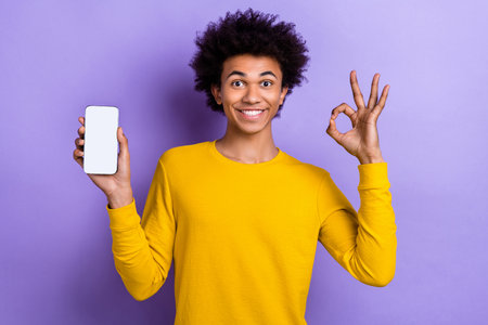 Photo advertisement original design smartphone qr code promo young guy hold gadget showing okey symbol isolated on purple color backgroundの写真素材