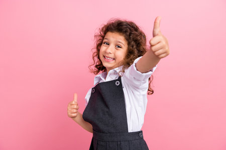 Portrait of little friendly schoolchild beaming smile arms fingers demonstrate thumb up isolated on...