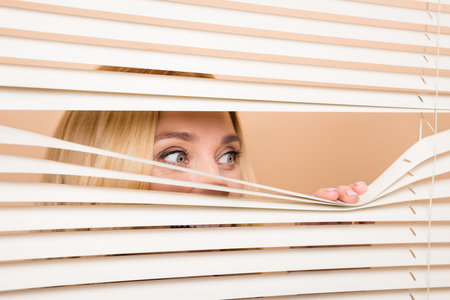 Photo of corporate manager lady arm open window shutter look interested isolated on beige color backgroundの写真素材