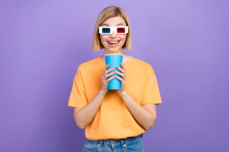 Photo of impressed girl with bob hairstyle dressed yellow t-shirt in 3d glasses drink lemonade at...