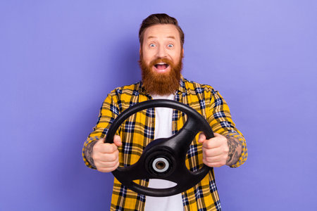 Photo of impressed cheerful person open mouth cant believe arms hold wheel isolated on violet color...