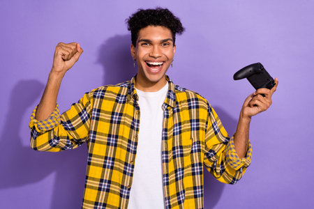 Photo of cheerful lucky guy wear plaid yellow shirt winning game isolated violet color background