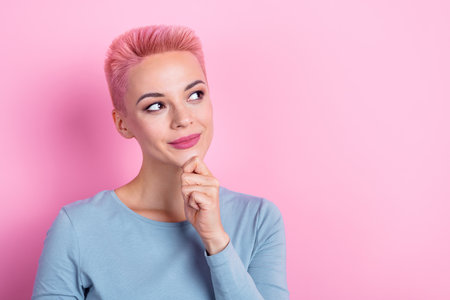 Portrait of minded girl wear stylish outfit touch face look empty space interesting idea offer poster isolated on pink color backgroundの写真素材