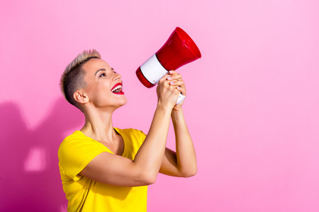 Profile photo of nice cheerful person arms hold loudspeaker toa communicate empty space isolated on pink color backgroundの写真素材