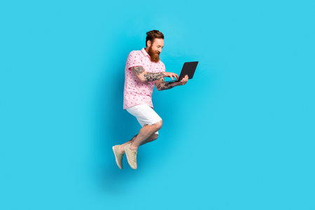 Full length profile portrait of crazy energetic guy jump running use wireless netbook isolated on...