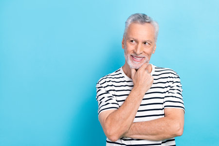 Photo of thoughtful positive man wear striped white t-shirt arm chin looking empty space isolated...