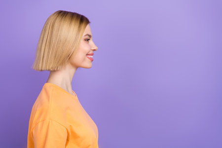 Profile portrait of amazing young girl beaming smiling looking empty space wearing t-shirt isolated purple color backgroundの写真素材