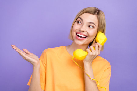 Portrait of cheerful adorable woman with bob hairdo wear stylish t-shirt talk on phone look empty...