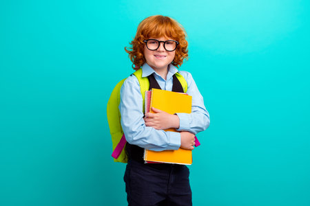 Photo of cheerful cheerful person carry backpack hold copybook notebook isolated on teal color backgroundの写真素材