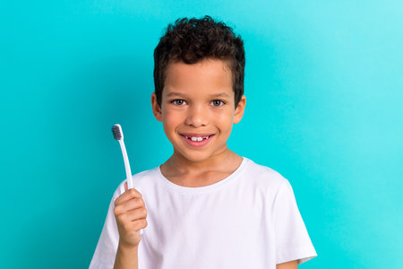 Photo of cute cheerful funky person toothy smile hand hold toothbrush isolated on teal color backgroundの写真素材