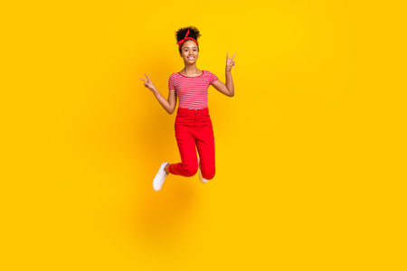 Full body photo of pretty young girl jumping showing v-sign summer wear trendy red striped outfit...