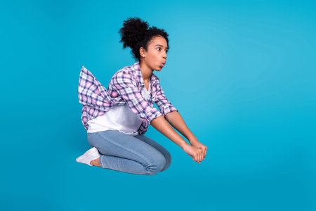 Full length photo of sweet shocked girl dressed plaid shirt jumping high rising motocycle isolated...