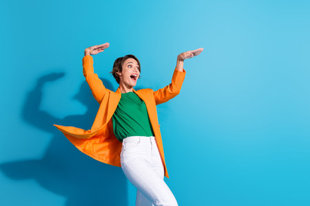 Photo of energetic young businesswoman formal elegant clothes hands up rhythm boogie woogie look mockup isolated on blue color backgroundの写真素材
