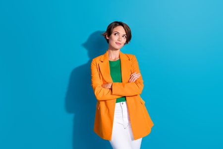 Portrait photo of young dreamy businesswoman guessing intellectual creative ideas strategy planning isolated on blue color backgroundの写真素材