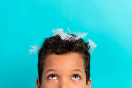 Close up cropped photo of schoolkid feathers head look interested up empty space ad isolated on cyan color backgroundの写真素材