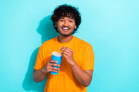 Portrait of cheerful person toothy smile hands hold plastic soda drink cup straw empty space...