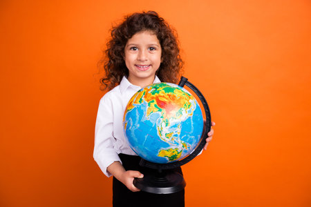 Photo of cute adorable school girl hold big globe learn continents country in class isolated bright color backgroundの写真素材