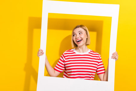 Photo of optimistic impressed overjoyed girl with afro chevelure wear pink t-shirt holding soccer ball isolated on blue color backgroundの写真素材