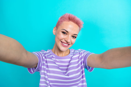 Photo of gorgeous positive lady beaming smile good mood make selfie recording video isolated on teal color backgroundの写真素材