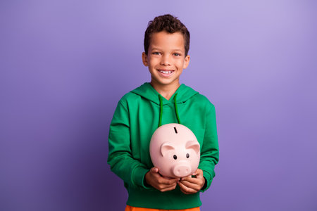 Photo of nice cute latin rich boy wear green stylish clothes hold piggy bank financial future...