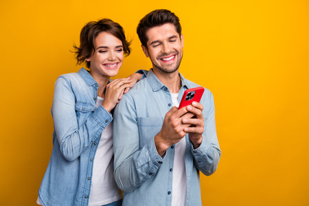 Photo of positive millennial couple lady guy using gadget online shopping isolated on shine color backgroundの写真素材