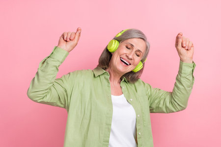 Photo of overjoyed optimistic lady wear green stylish clothes have fun dance enjoy good mood isolated on pink color backgroundの写真素材
