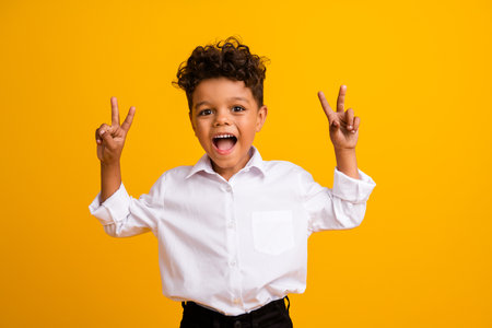 Portrait of impressed crazy funny boy with wavy hairdo wear stylish shirt showing v-sign symbol...