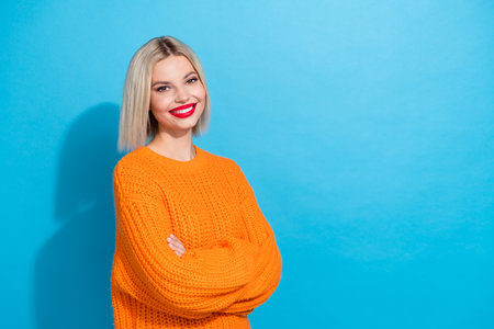 Portrait of good mood positive woman with bob hair dressed knitwear sweater standing hands folded isolated on blue color backgroundの写真素材