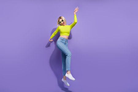 Full length photo of overjoyed nice girl wear trendy clothes having fun good mood isolated on purple color backgroundの写真素材