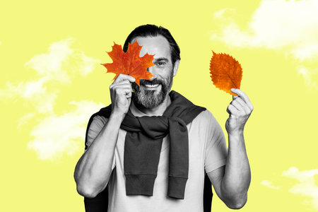 Collage picture of positive black white colors man hold fallen leaves cover one eye clouds sky isolated on yellow backgroundの写真素材