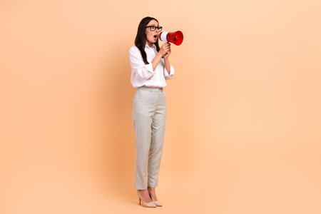 Full body photo of young business lady boss scream bullhorn announcement information empty space news isolated on beige color backgroundの写真素材
