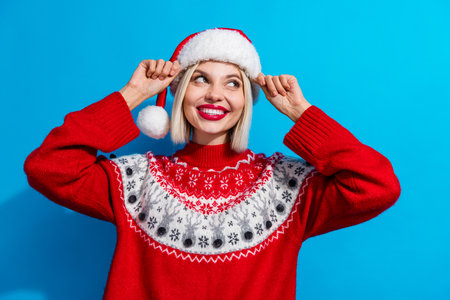 Photo of dreamy sweet woman lady santa elf wear ornament pullover looking empty space isolated blue color backgroundの写真素材
