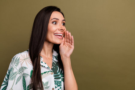 Portrait of impressed woman wear stylish shirt looking empty space hand on cheek announcing sale isolated on brown color backgroundの写真素材