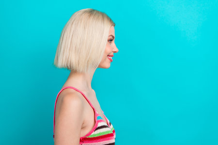 Photo of cheerful positive lady wear striped singlet looking empty space isolated turquoise color backgroundの写真素材