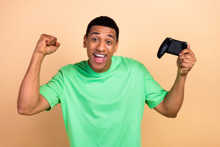 Photo portrait of handsome young guy raise fists celebrate victory wear trendy green garment...
