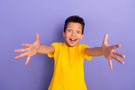 Photo of positive crazy good mood boy wear yellow trendy clothes hugging you isolated on purple color backgroundの写真素材