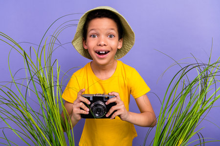 Photo of excited positive optimistic boy wear trendy yellow clothes filming tropic nature isolated...