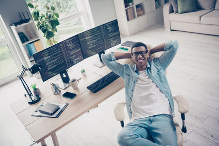 Photo of cheerful happy guy system administrator optimized all his job to automatic mode just chilling sit armchair isolated in officeの写真素材