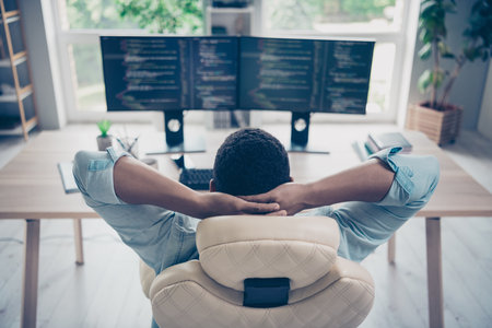 Rear photo of server operator successful guy it developer relaxing he done project hands head sitting armchair reviewing code on monitorsの写真素材