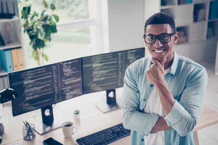 Photo of positive young funny man startup programmer nft collection designer coder test his new...