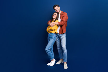 Full size photo of idyllic positive partners cuddle good mood empty space isolated on blue color backgroundの写真素材