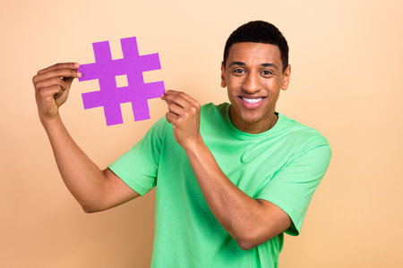 Photo portrait of nice young guy hold hashtag social media wear trendy green garment isolated on...