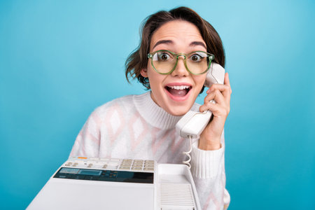 Portrait of impressed funky person communicate speak retro cable telephone isolated on blue color...