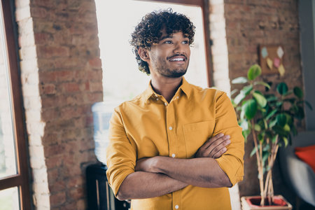 Photo portrait of young male wear yellow shirt confident boss crossed hands confident interior loft industrial styleの写真素材