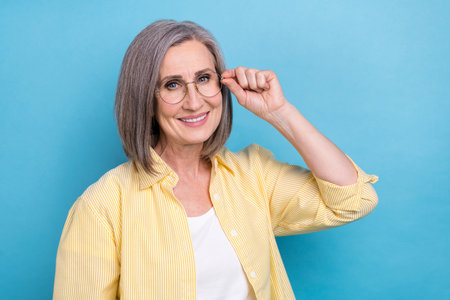 Photo of adorable cute woman dressed yellow shirt arm spectacles empty space isolated blue color...