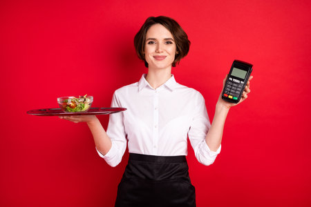 Photo of optimistic nice brunette hair lady hold food terminal wear shirt isolated on red color backgroundの写真素材